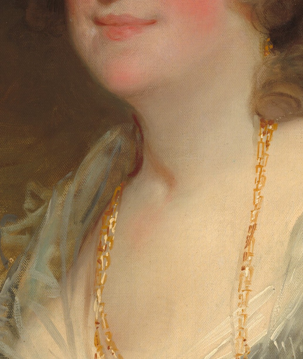Warm gold against cool grey fabric creates deliberate color contrast; chain's weight implies wealth and status