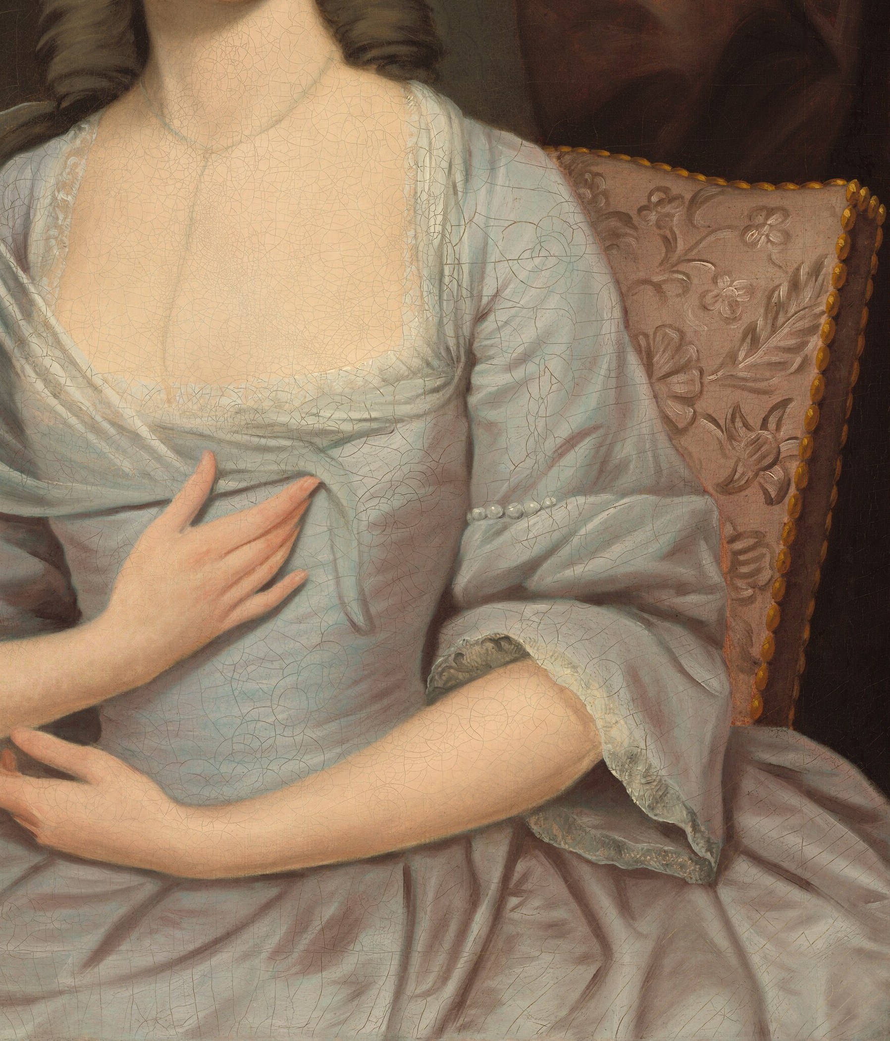 The soft fabric and low neckline of the dress reveal the fashion and social norms of the period.