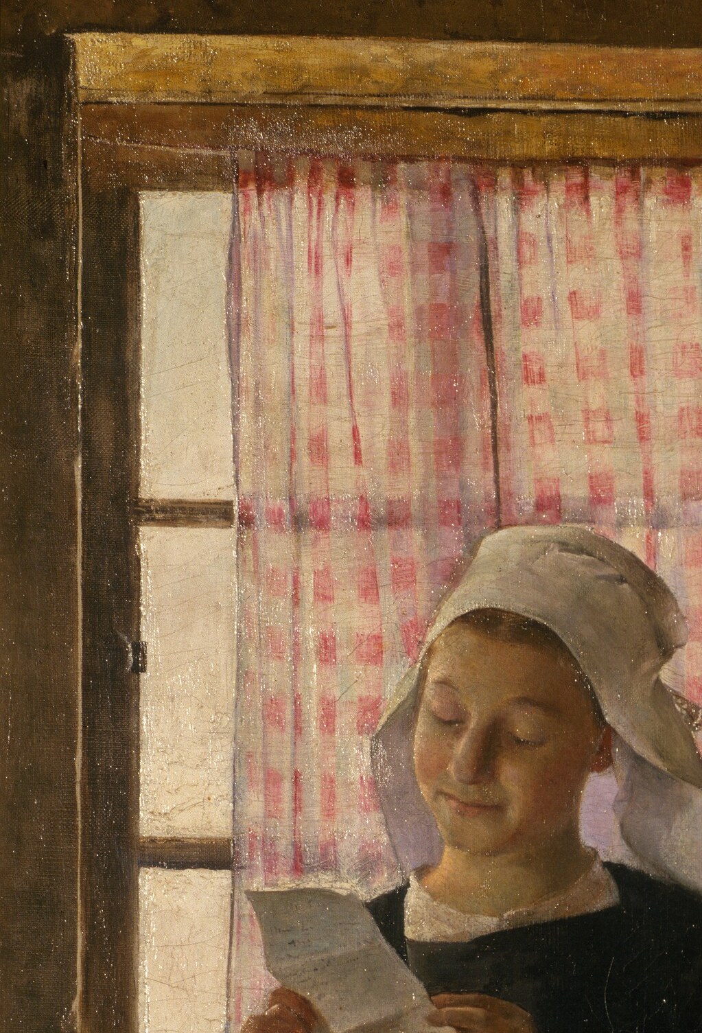The light from the window highlights her focused reading.