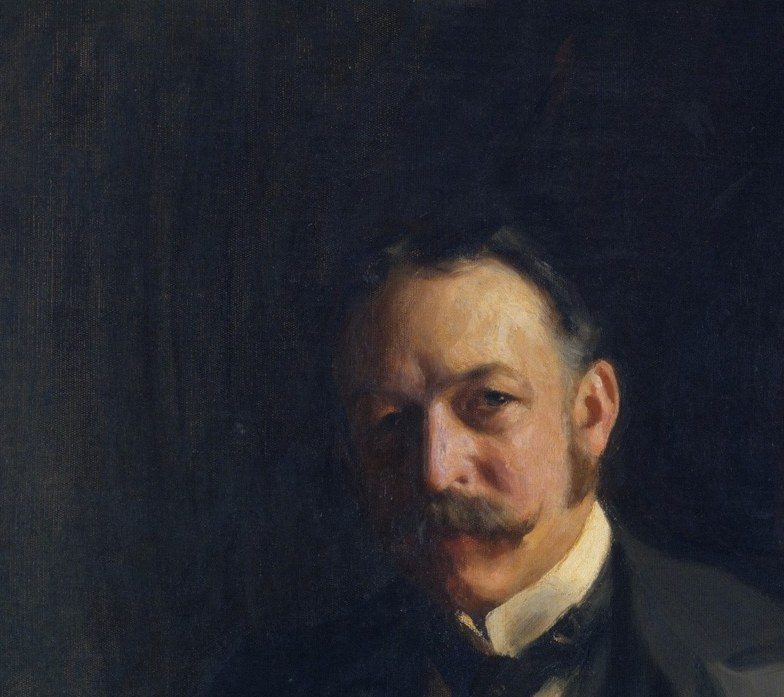 His eyes hold the room with a quiet, appraising authority.