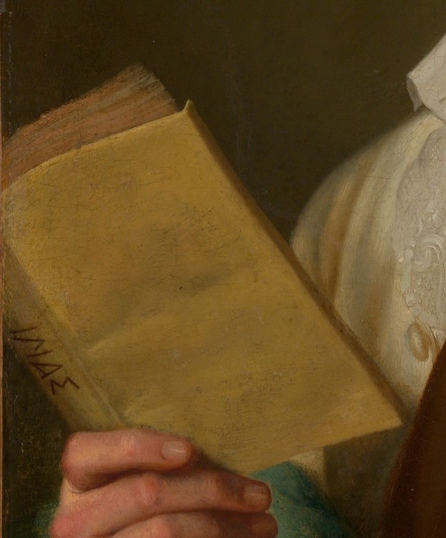 Look closely at the open book in his hands.