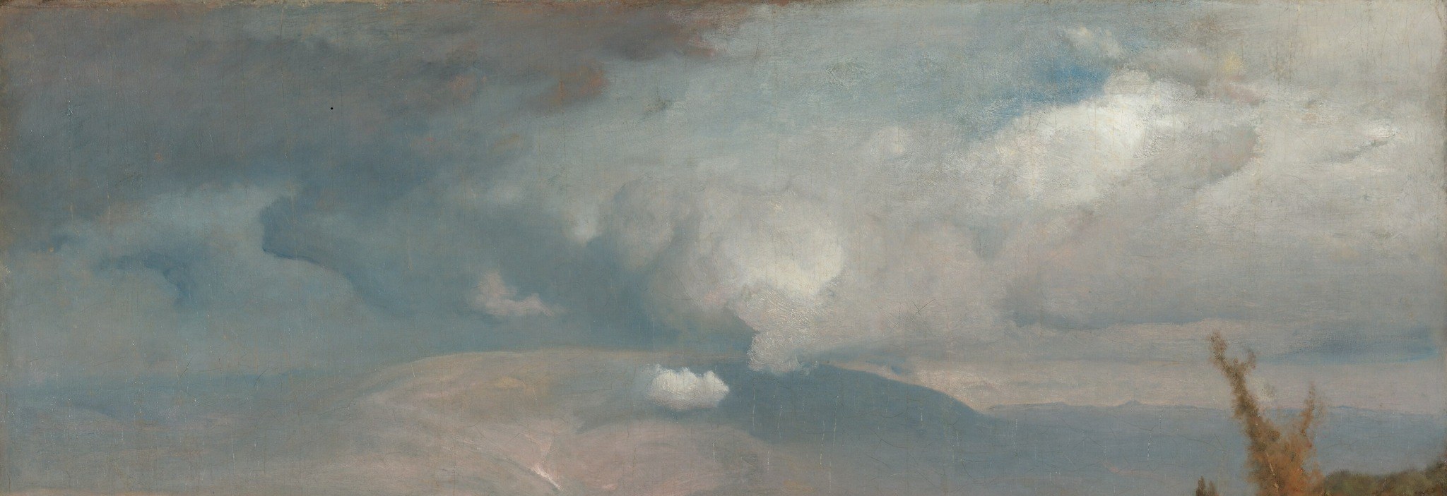 Heavy clouds gather over distant, hazy mountains.