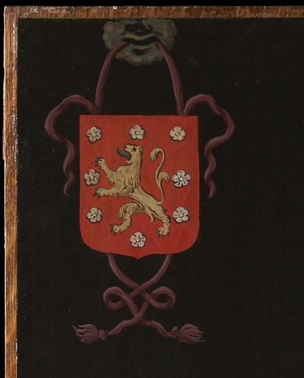 A red shield with heraldic charges: a lion and flowers.