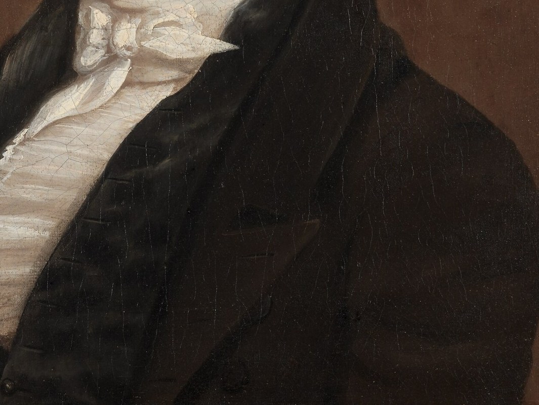 The dark, formal jacket suggests his social standing and the seriousness of the occasion.
