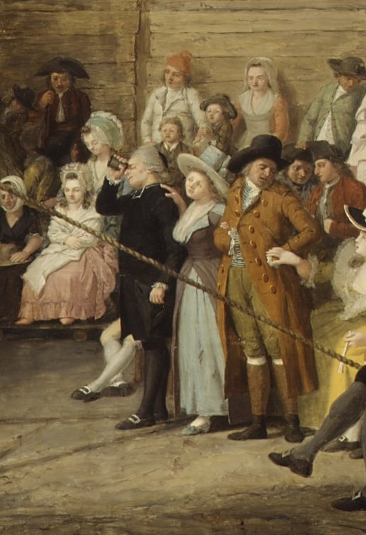 Her lighter dress echoes the dancer's costume, visually linking performer and audience; her posture or expression may betray anxiety or delight.
