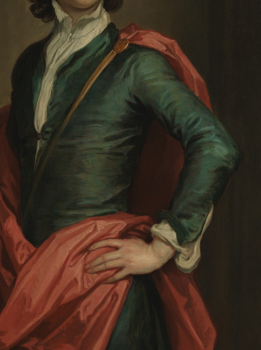 The rich, textured fabric and tailored fit highlight his aristocratic bearing.