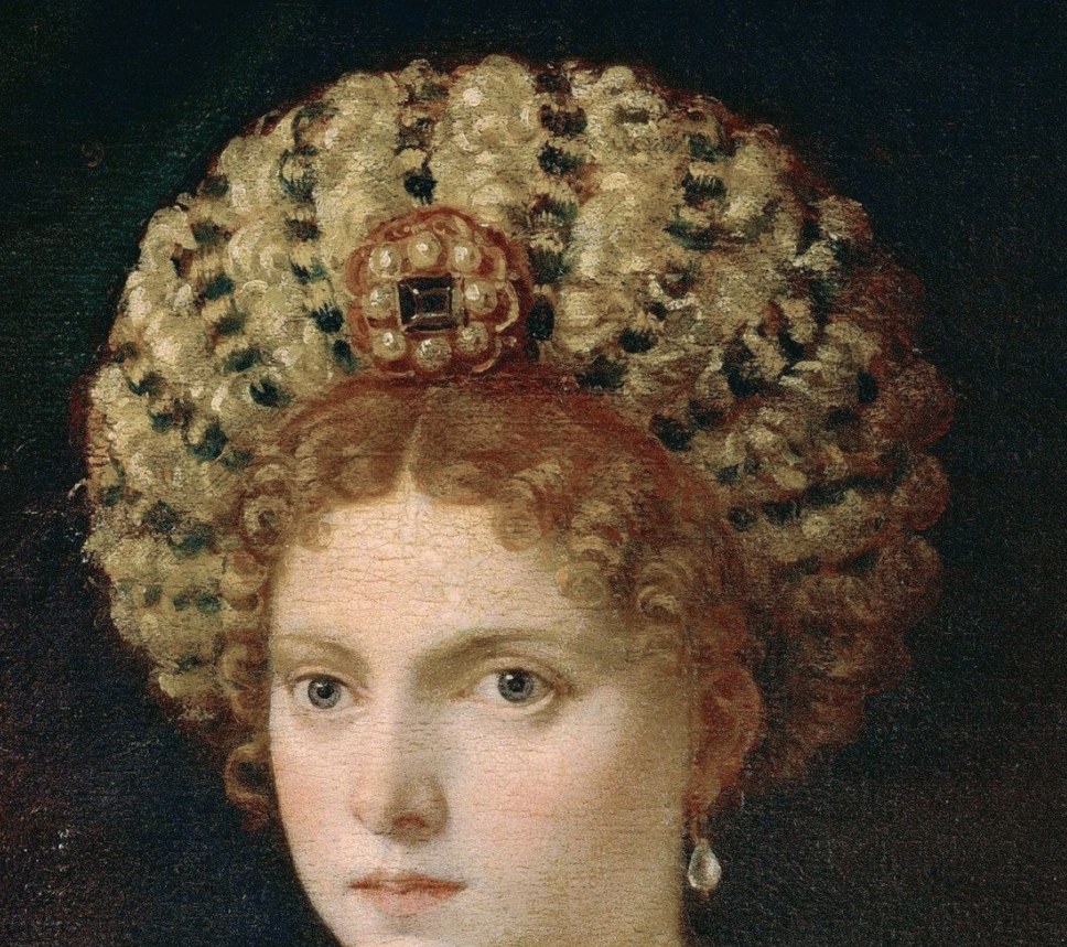 Her elaborate headdress and jewels signal high status.