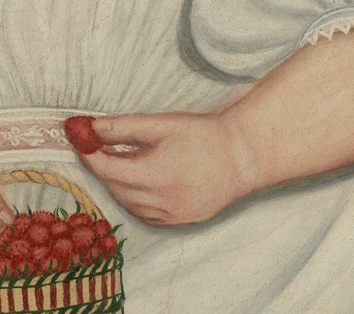 Her hands hold a basket of cherries.