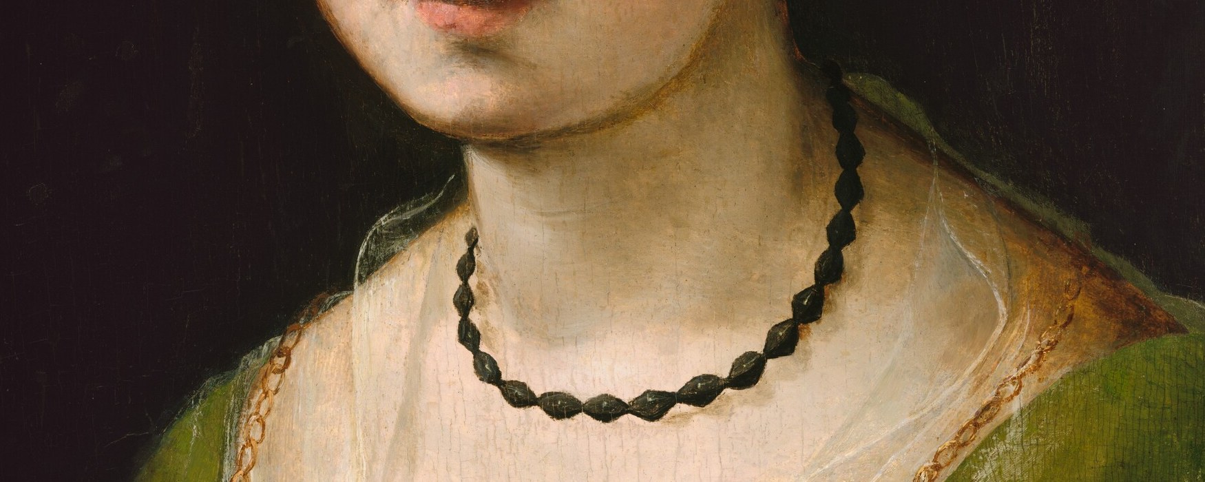 Now the necklace. Jet or dark coral beads at her throat.