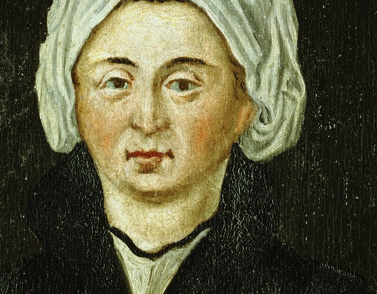 Her face is still. She looks straight at you.