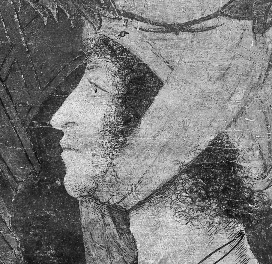 The closed eyes and stone niche suggest a tomb sculpture.