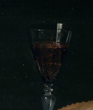 The dark liquid and the elegant glass suggest a refined beverage, adding a touch of luxury.