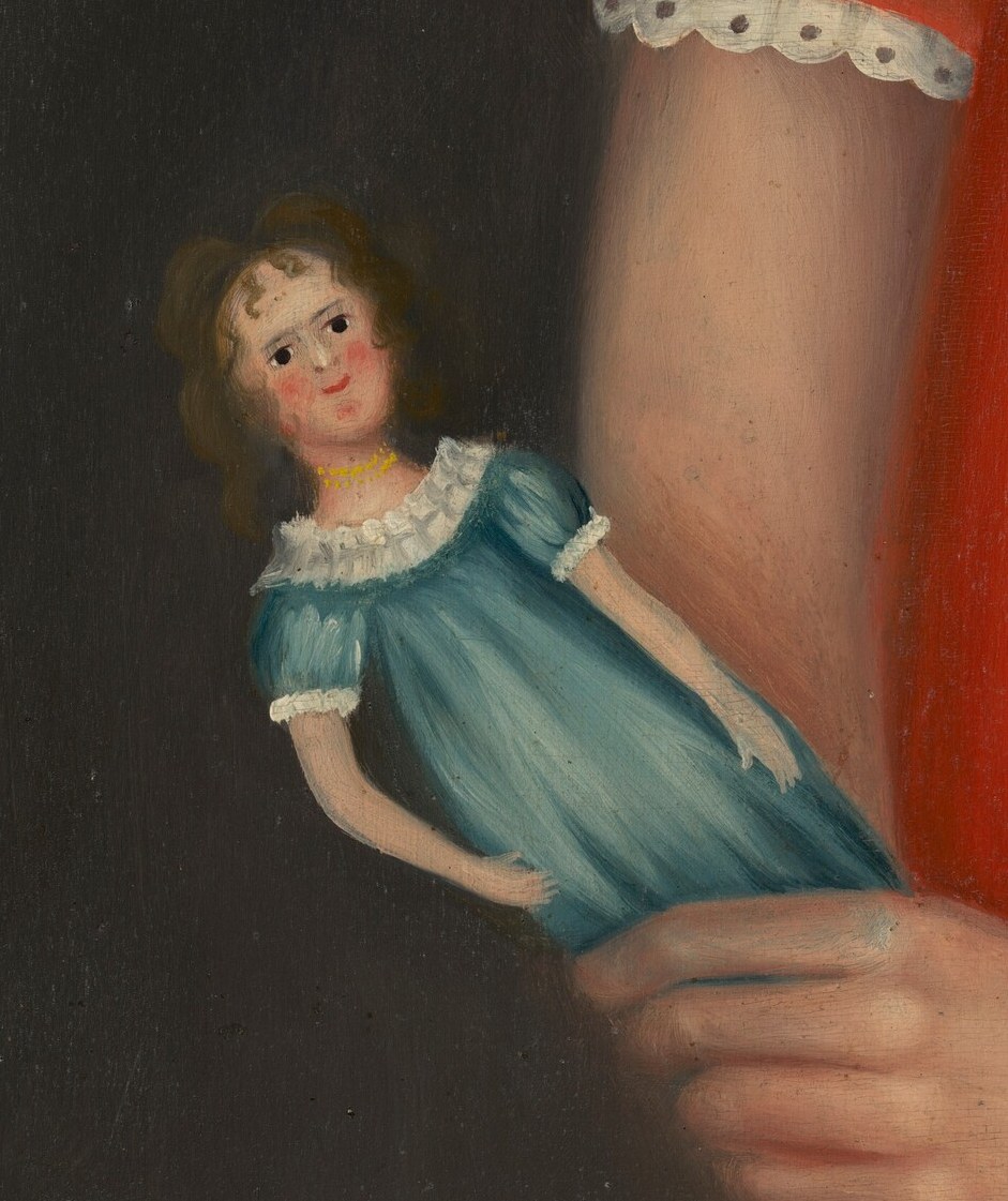 Her small doll, in its blue dress, was likely handmade.