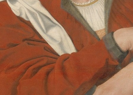 His wife, however, looks at an open book, possibly scripture.