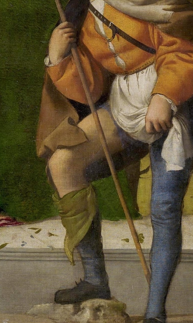 His saintly brother holds a pilgrim's staff.