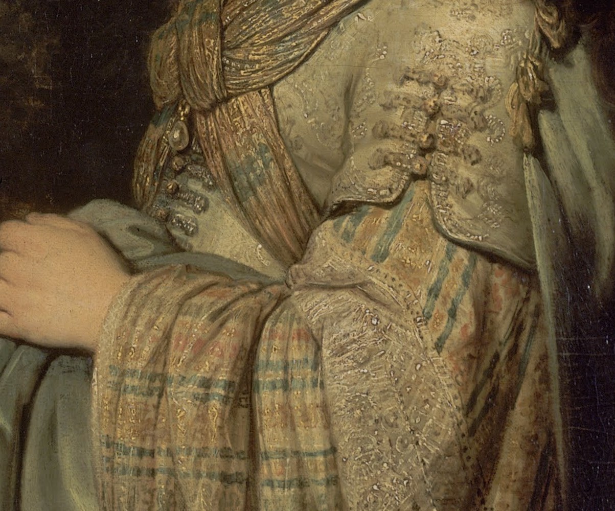 Look closer at the intricate embroidery on her sleeve.