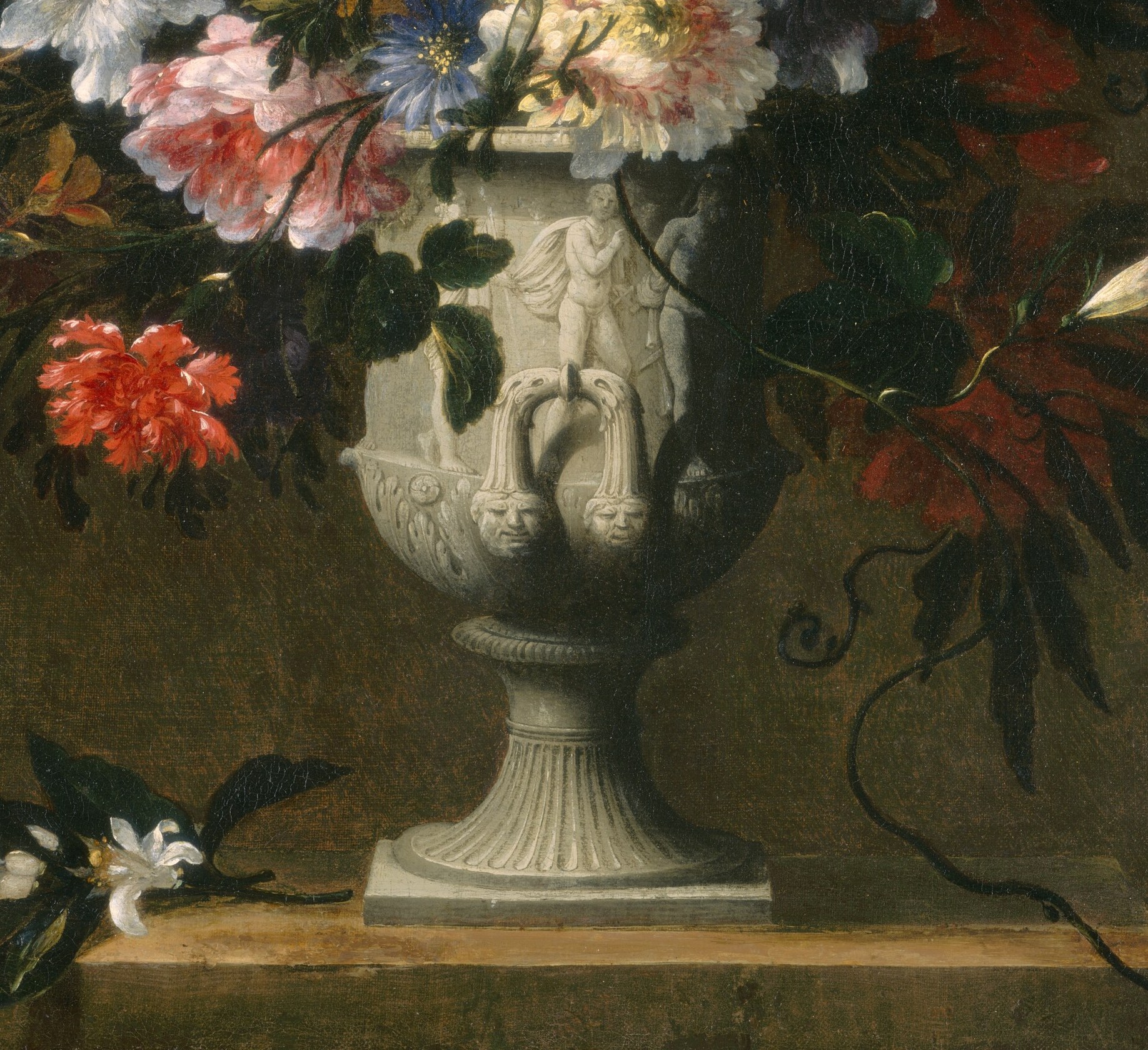 The anchor of the composition , a pale stone-coloured urn with sculpted handles and bas-relief motifs; its ornate surface contrasts with the natural softness of the flowers above.