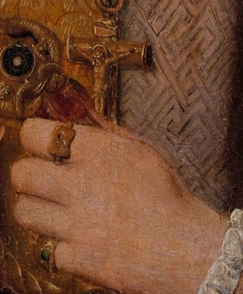 In his hand, he holds a small, cross-like object.