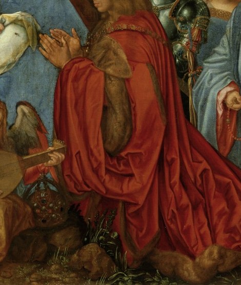 The vibrant red and elaborate drapery suggest high status and deep devotion, drawing the eye with its texture and color.