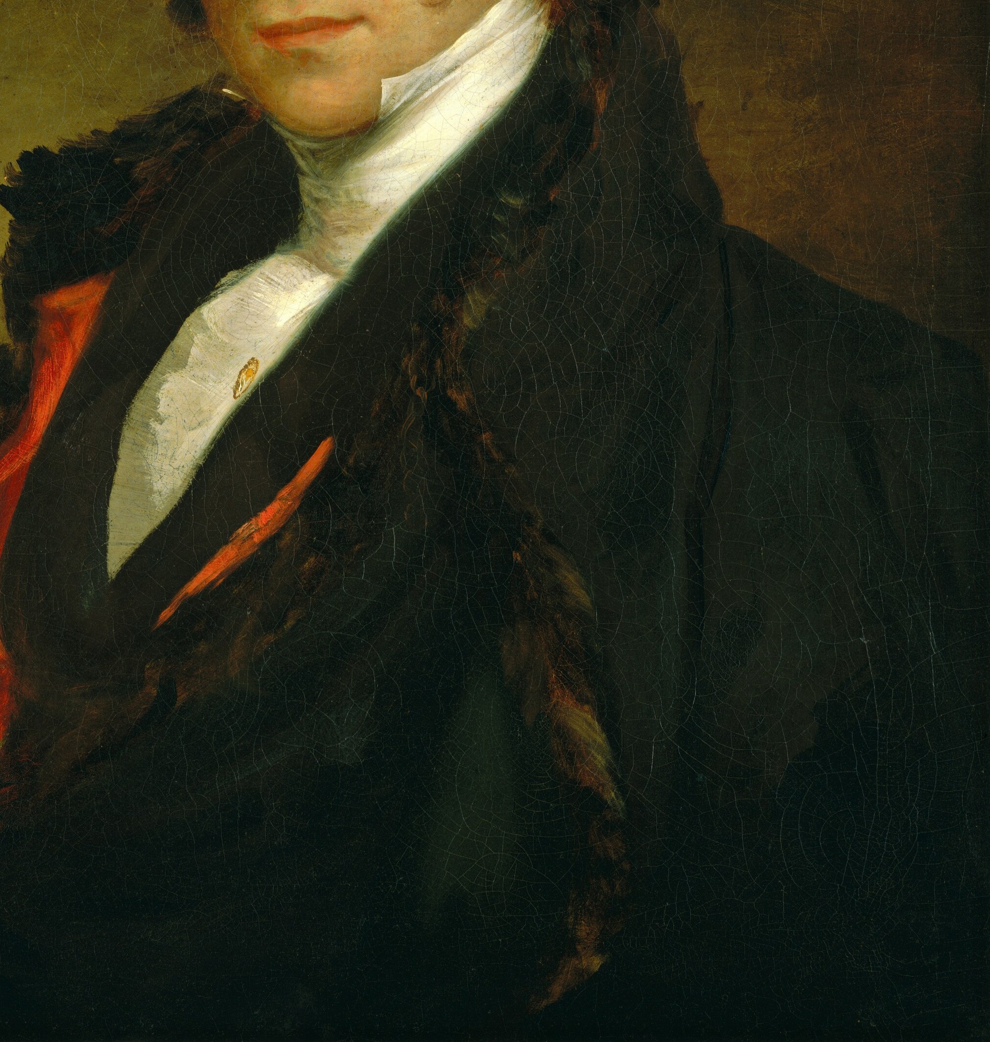 His fur-trimmed coat and vibrant red vest speak of wealth.