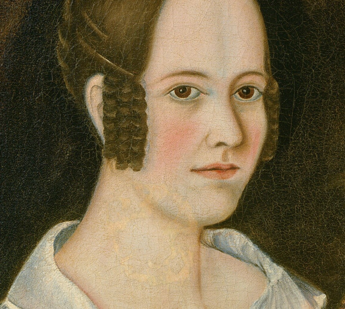 Her steady gaze and composure are the central focus.