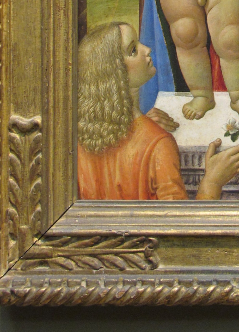 Wingless or winged attendant figure whose gaze and gesture direct devotional attention upward to the Madonna , a compositional usher for the viewer.