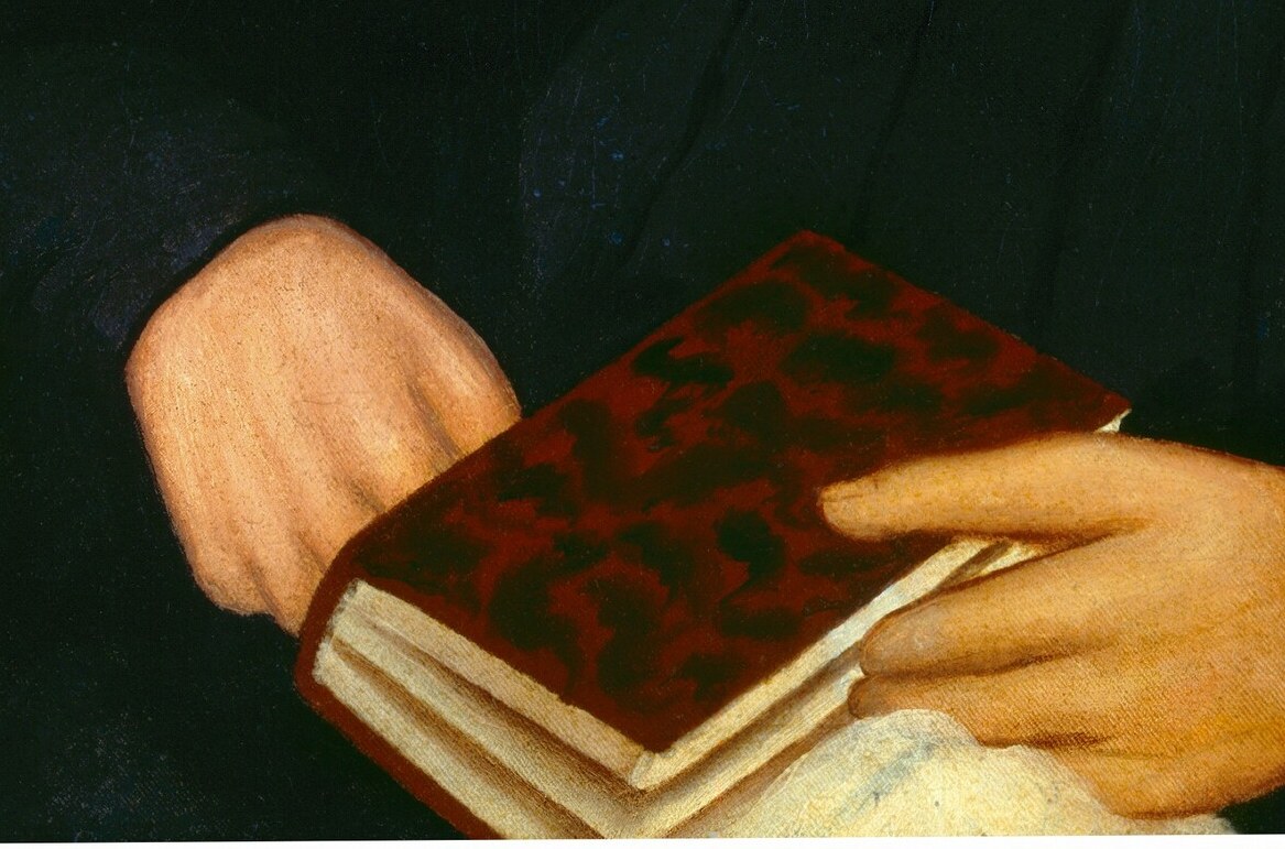 The gentle pose of her hands holding the book conveys a sense of calm and composure.