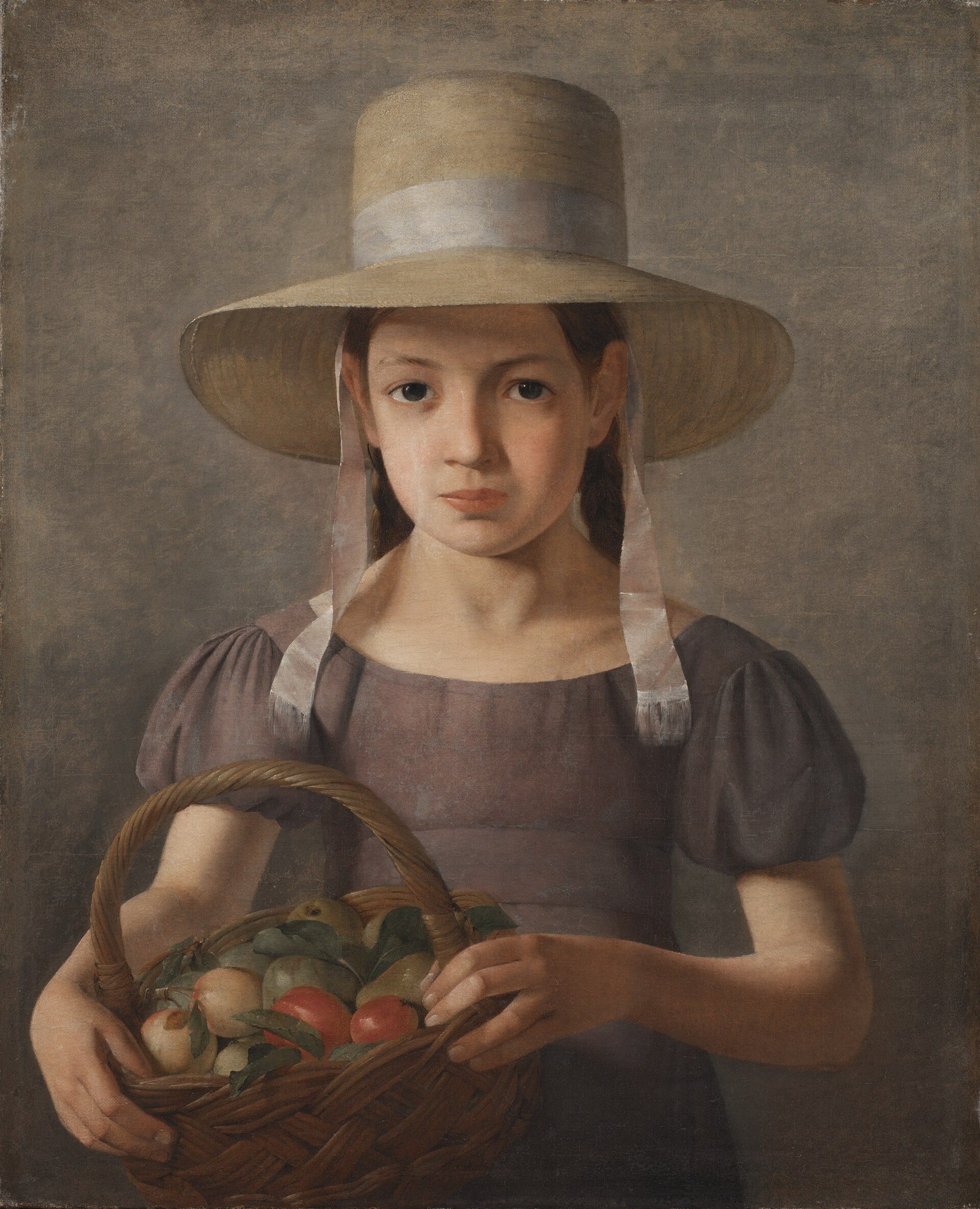 The plain background emphasizes the subject and allows the viewer to focus on the girl and her fruit.