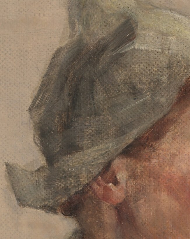 Her wide-brimmed hat casts shadows, adding to her reflective mood.