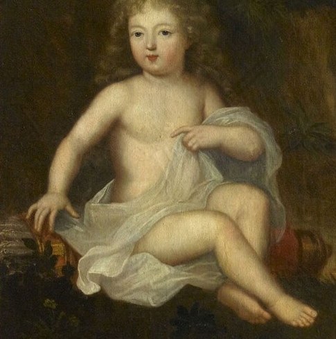 A younger child plays on the ground.