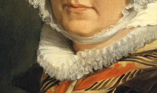 This crisp white collar contrasts with her dark dress and frames her face, adding a touch of elegance.