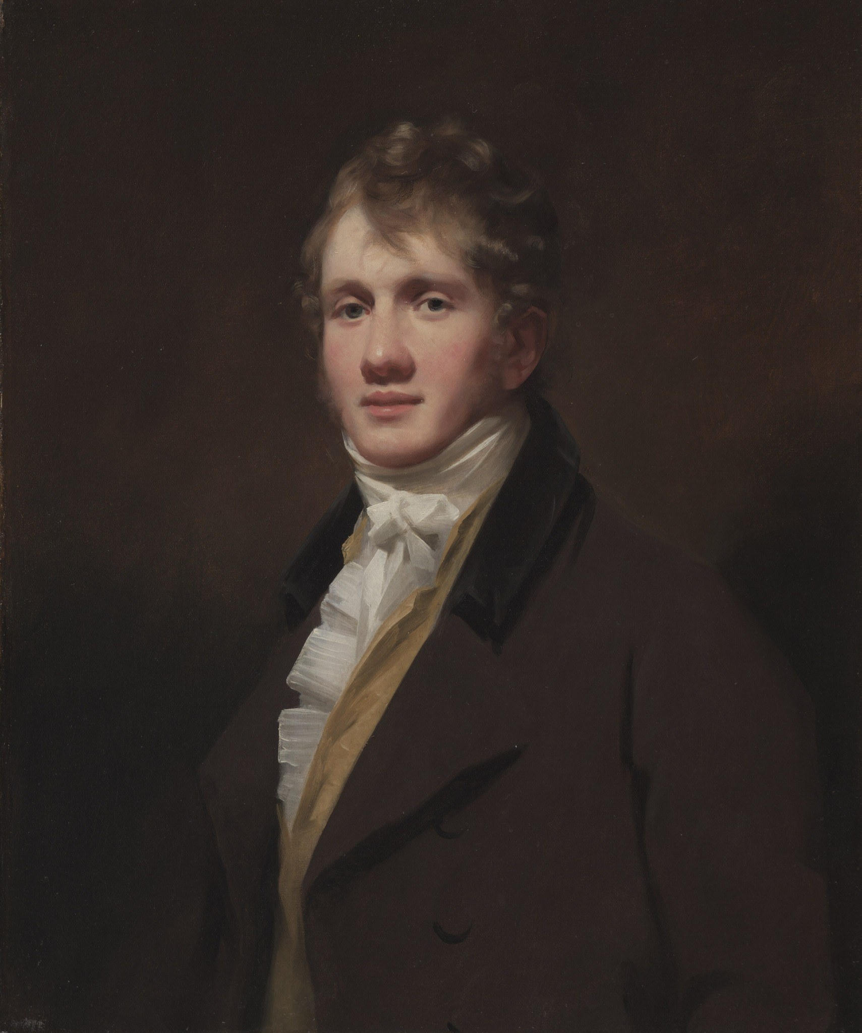 The somber, undefined background isolates the subject and focuses attention on his presence.