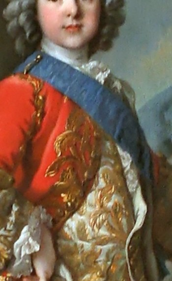 The blue sash frames the chest as a sacred zone of inherited power.