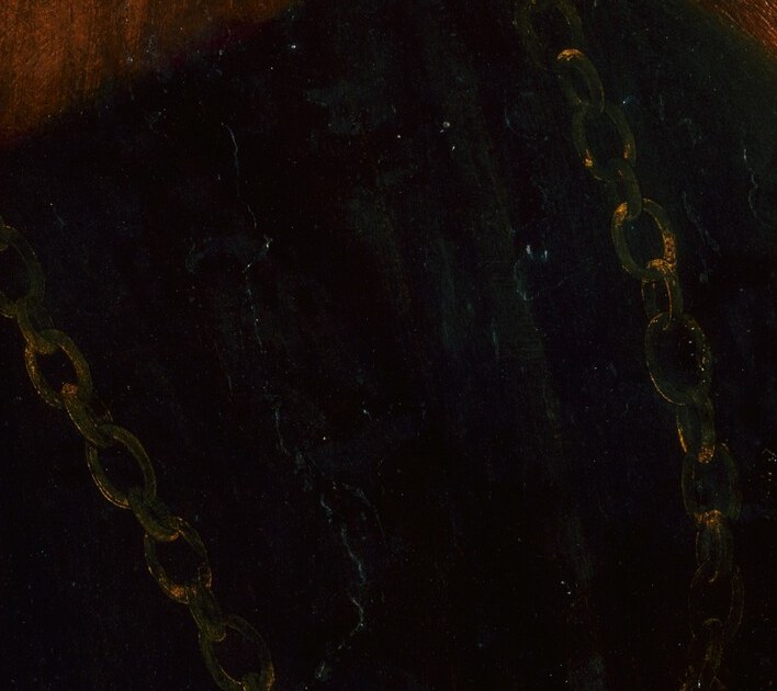 His heavy gold chain marks him as a nobleman.
