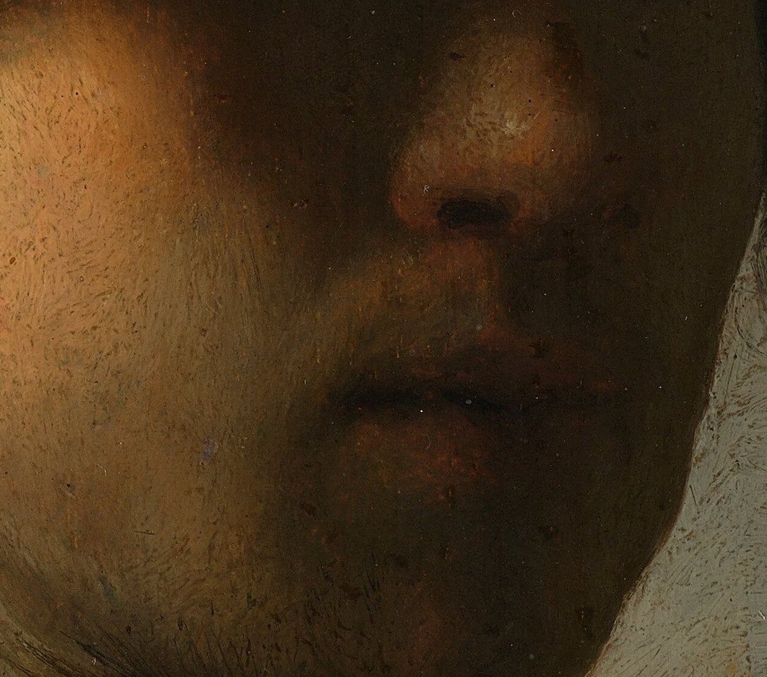One side of his face catches the light.