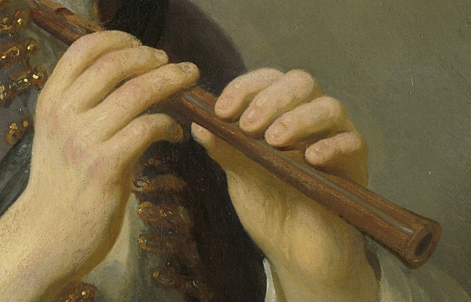 The instrument is held with delicate precision, highlighting the musician's skill and the tactile quality of the wood.