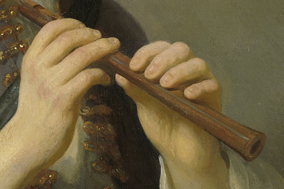 His hands hold a wooden flute, fingers placed with precision.