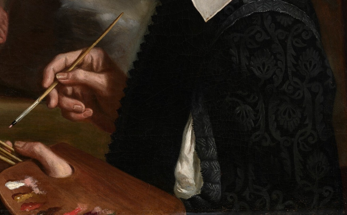 In his hands: the palette. He is showing you who he is.