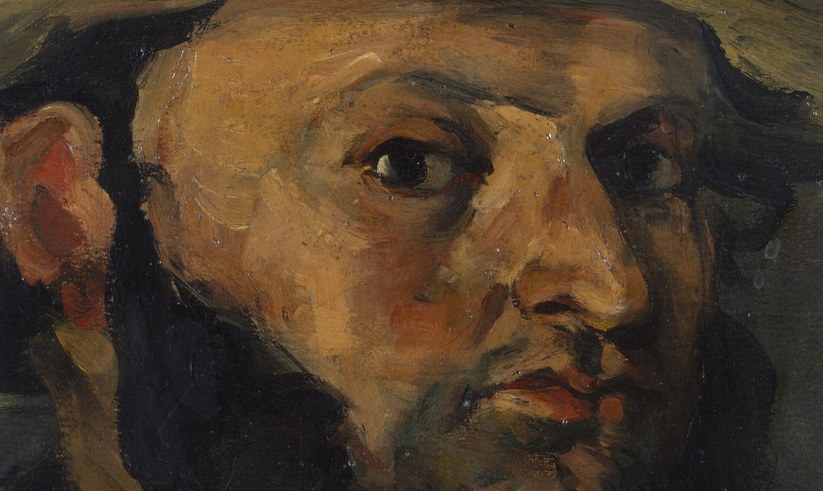 His eyes are dark, skeptical, nearly lost in shadow.