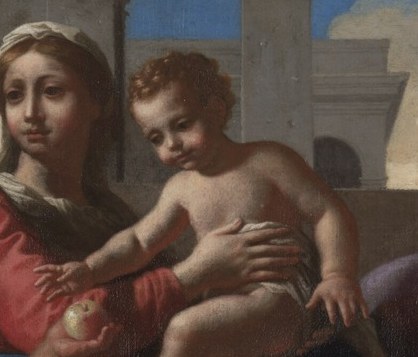 His infant hand reaches for it.