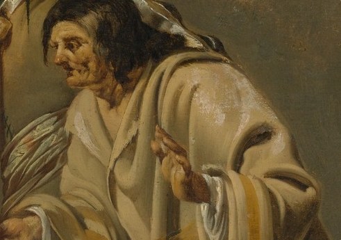 The fortune-teller extends a small object toward the gentleman's open hand.