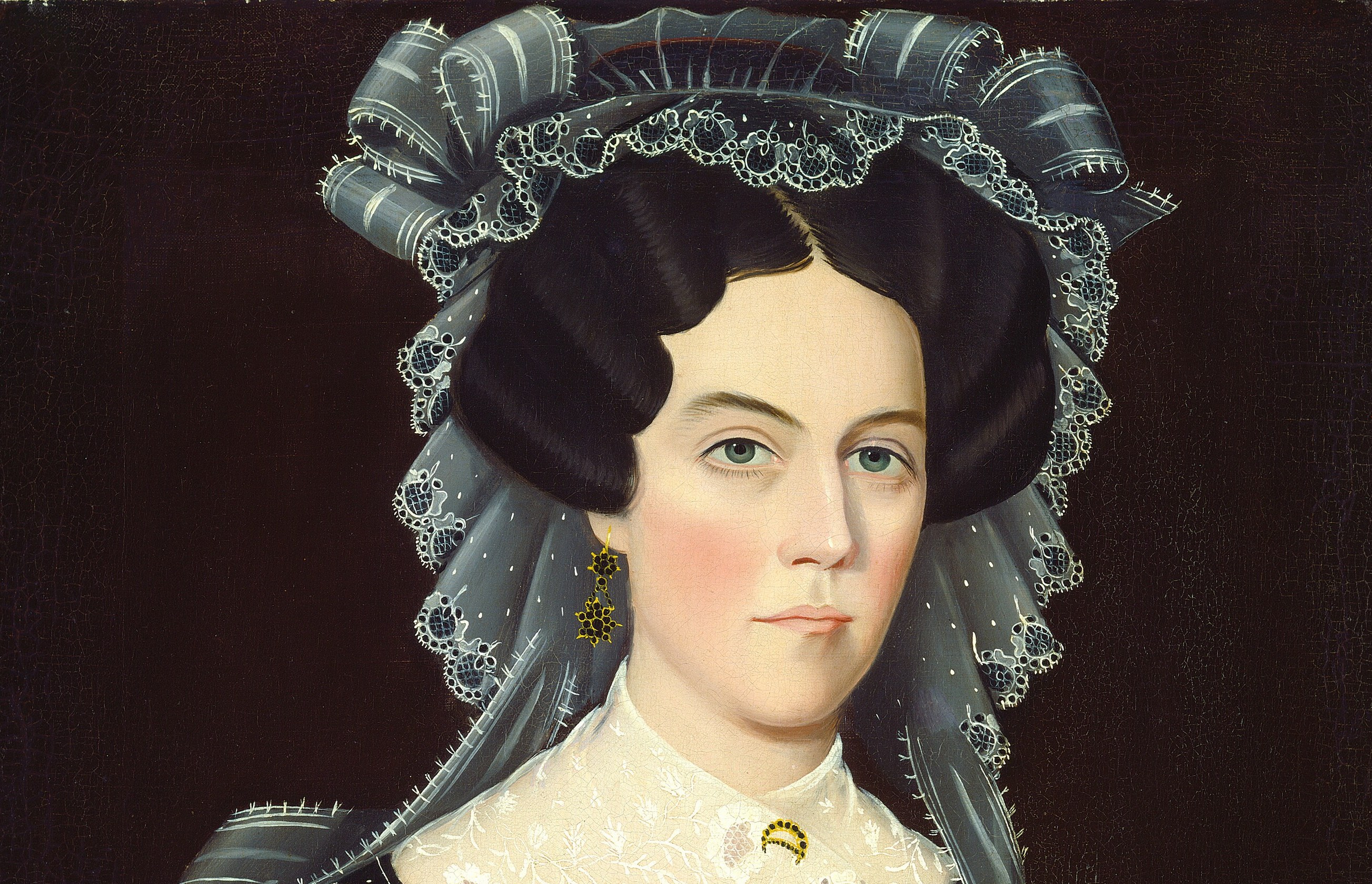 The bonnet's crisp white lace ruffles frame the face like a halo and its dark silk ribbons date the costume precisely to c.1828-1832 Regency fashion , a social signifier of genteel status.