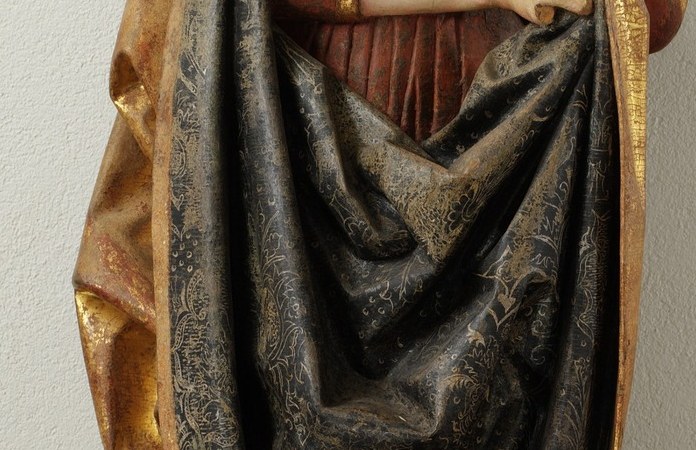 Primary identifying attribute after the tower , symbolizes sacred learning and Barbara's faith; its compact size shows her grip as protective rather than scholarly