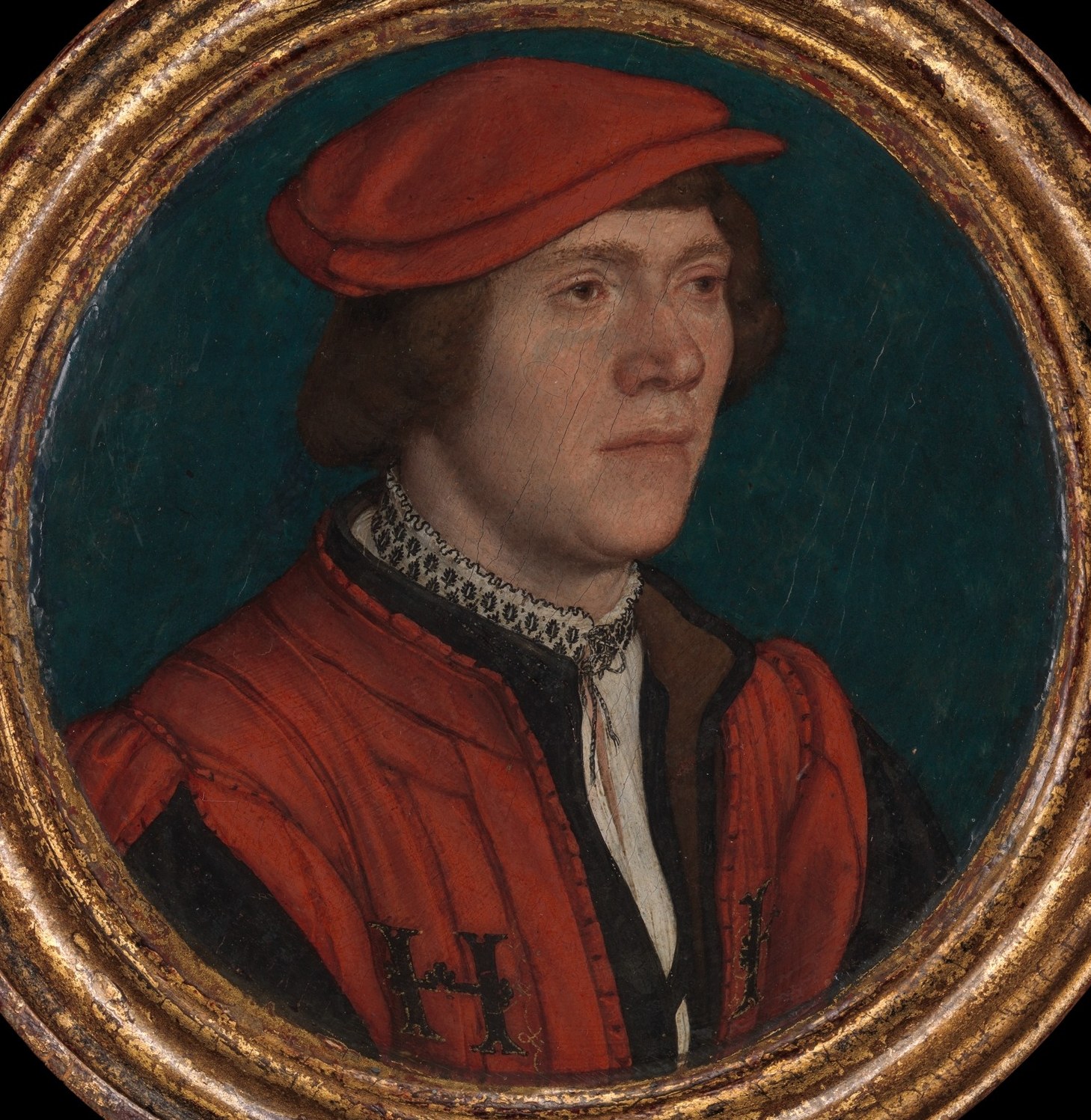 The plain, dark background isolates the subject, focusing all attention on his presence and attire.