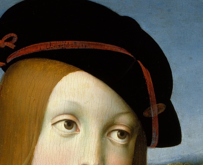 The dark, structured hat contrasts with his soft features and signifies his status.