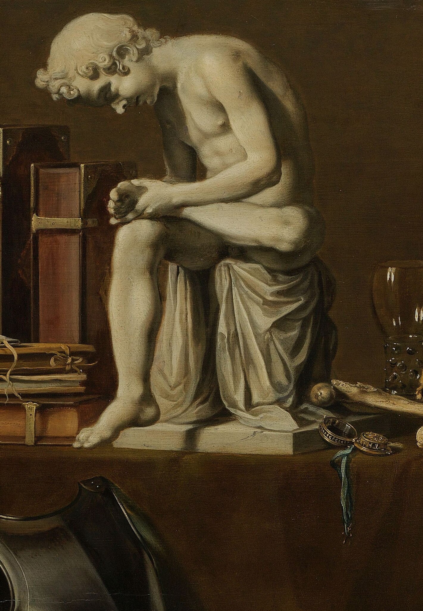 The conceptual anchor of the painting , a copy of an ancient Roman bronze placed among mortal symbols; the act of extracting pain is itself a vanitas gesture, and its chalk-white pallor echoes the skull beside it.