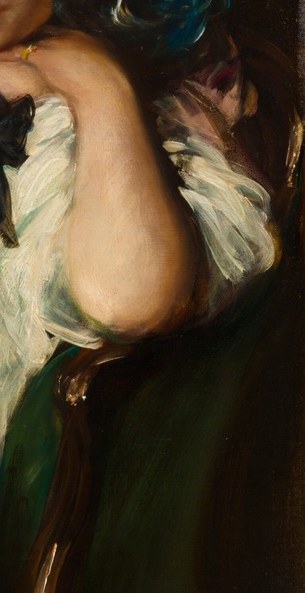 She sits in an ornate green chair.