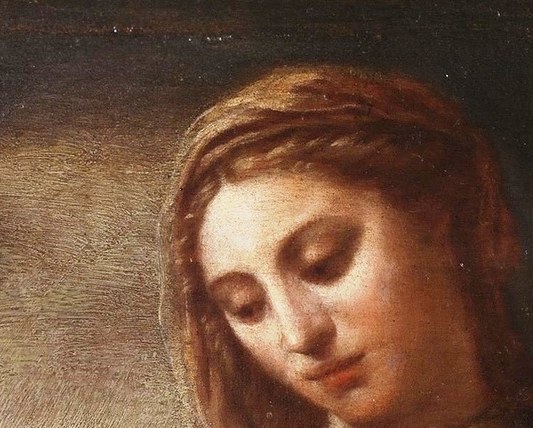 Her gaze is directed downwards, conveying tenderness and maternal love towards the child.