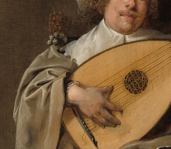 The active strumming hand at the soundhole translates music into visible gesture; a close-up here makes the performance tangible.