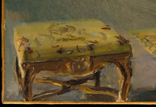 Its patterned fabric and gilded legs suggest comfort and refined taste, a detail for close inspection.